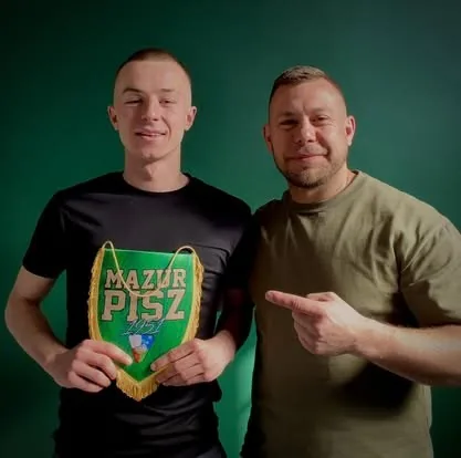 Adam Obrycki z młodym zawodnikiem i proporczykiem klubu